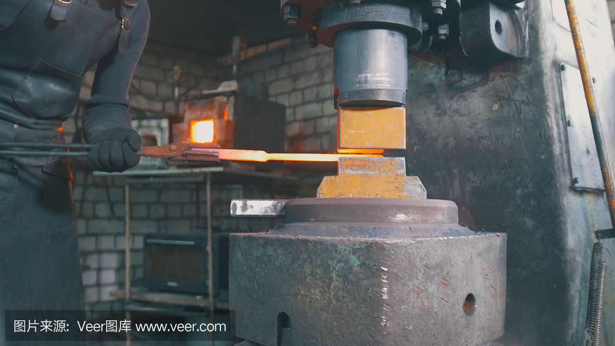 自动锤击——铁匠在铁砧上锻造炽热的铁块,特写镜头